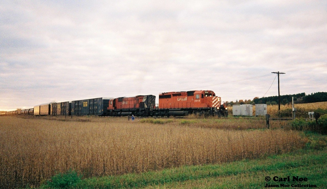 A CP eastbound is viewed departing the siding at Wolverton, Ontario on the Galt Subdivision with SD40-2 5916 and M-636 4709 after meeting a westbound with 5793 and 5513.