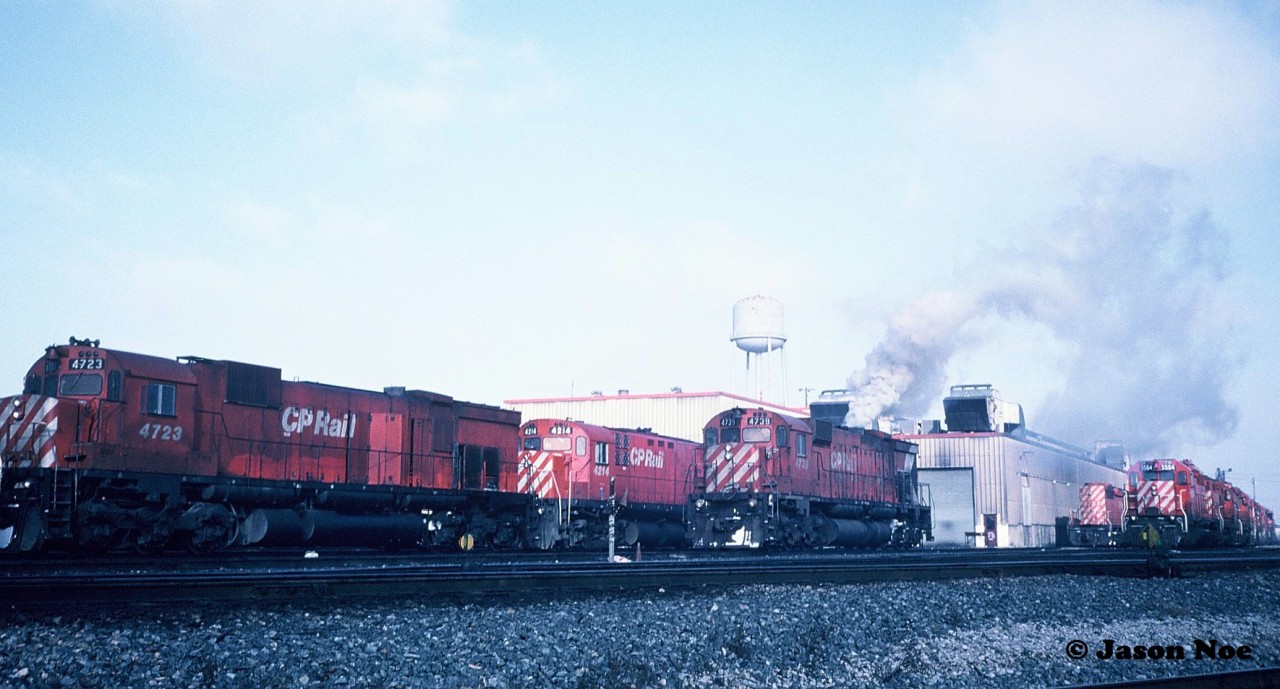 In fall 1993, my dad and I through another friend had met another railfan that lived in Kitchener named Andy. Up until that point during my first year doing train photography, I always used print film. I had started my train photo albums that spring and they were nicely filling with shots from Kitchener and Waterloo as well as Ayr, Paris, Woodstock and the London area. Not long after meeting Andy, he had invited myself and another friend to a train slide show as he had been photographing trains since the early 1980’s. I had never been to a slide show before, however by the time the last slide dropped in the projector, I knew I had shot my last roll of prints. Seeing all the older slides blown-up on screen looking like they had just been taken yesterday was enough to convince me to make the switch. Andy had travelled all over the US and Ontario photographing trains and the one place he frequented often was Toronto. After seeing his stuff, I immediately went home and convinced my dad we had to go!

So the story goes, during two separate Saturday mornings during late 1993, my dad, Andy and another friend had headed east in my dad’s plumbing van to Toronto. By now my Kodak camera was loaded with my first roll of Kodachrome slide film. As we entered CP’s Agincourt yard I immediately knew it might be going to be used rather quickly seeing all the locomotives sitting by the diesel shop and switching the various tracks.

Here one of the highlights during one of those mornings was photographing big M-636 4739 at the shop knowing that it could be retired soon. This scan shows 4739 coming to life as shop crews start it up while several other MLW’s look on including fellow M-636 4723.