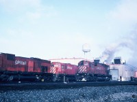 In fall 1993, my dad and I through another friend had met another railfan that lived in Kitchener named Andy. Up until that point during my first year doing train photography, I always used print film. I had started my train photo albums that spring and they were nicely filling with shots from Kitchener and Waterloo as well as Ayr, Paris, Woodstock and the London area. Not long after meeting Andy, he had invited myself and another friend to a train slide show as he had been photographing trains since the early 1980’s. I had never been to a slide show before, however by the time the last slide dropped in the projector, I knew I had shot my last roll of prints. Seeing all the older slides blown-up on screen looking like they had just been taken yesterday was enough to convince me to make the switch. Andy had travelled all over the US and Ontario photographing trains and the one place he frequented often was Toronto. After seeing his stuff, I immediately went home and convinced my dad we had to go!
<br>
So the story goes, during two separate Saturday mornings during late 1993, my dad, Andy and another friend had headed east in my dad’s plumbing van to Toronto. By now my Kodak camera was loaded with my first roll of Kodachrome slide film. As we entered CP’s Agincourt yard I immediately knew it might be going to be used rather quickly seeing all the locomotives sitting by the diesel shop and switching the various tracks.
<br>
Here one of the highlights during one of those mornings was photographing big M-636 4739 at the shop knowing that it could be retired soon. This scan shows 4739 coming to life as shop crews start it up while several other MLW’s look on including fellow M-636 4723. 
