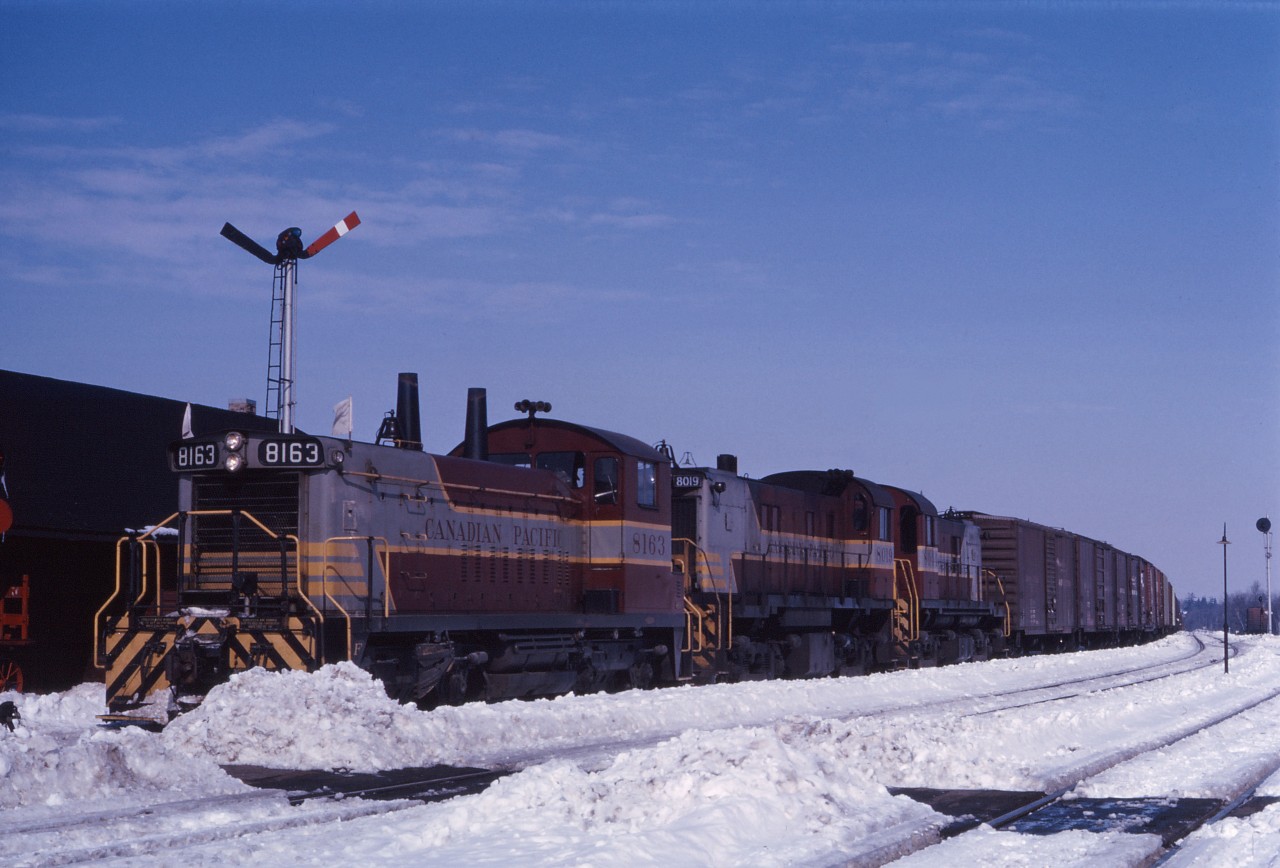 Three "branch line units" (8163, 8019, and 8044) lead an Extra West through Guelph Jct late in the winter of 1965. While Spring is supposed to be "just around the corner", there's still lots of snow on the ground on this bright day.