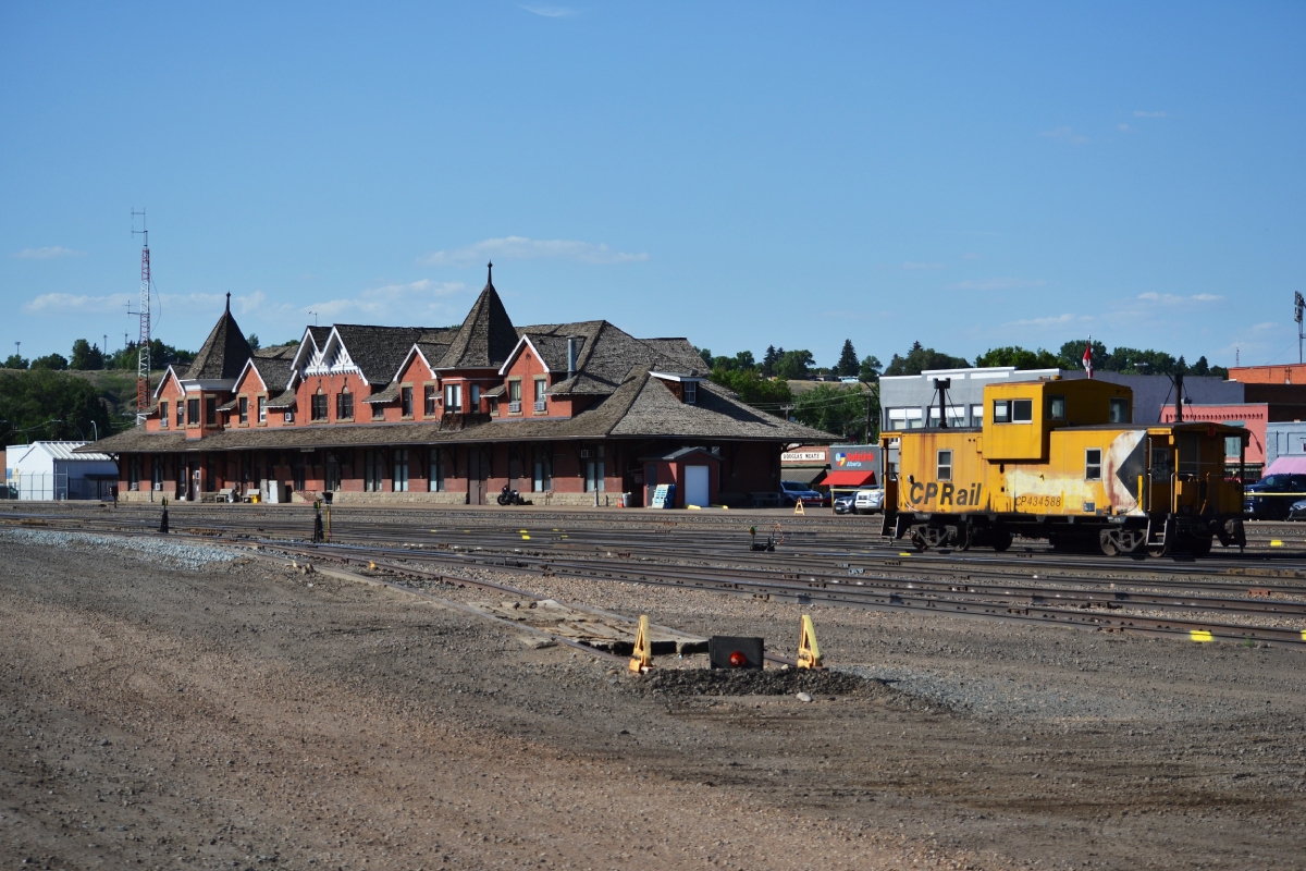 Two sights of a forgone time. 

From Historic Places;
The Canadian Pacific Railway (CPR) Station at Medicine Hat reflects the early 20th-century prosperity of western Canada, and the close relationship between the railway and local development in western Canada. Originally constructed in 1906 as part of a major local CPR redevelopment project, the station was doubled in size in 1911-12 in response to the booming local economy.

The Medicine Hat station is an early and important example of the picturesque aesthetic used for larger CPR stations during the early 20th century. The 1911-12 expansion added a near-mirror image of the original station to its southern end, and maintained its picturesque appearance.

The station retains vestiges of its original station garden, one of western Canada’s earliest railway gardens. 

CP 434588 however, albeit not as historically significant as the station, has faired well for being close to 50` years old. Interesting to note is that the Angus shops were able to churn out roughly one Angus van a day for close to $40,000.

Both stations and vans like this that used to litter the country and were synonymous with every day life, have and still are fading. Such stations like Ingersoll that are simply too far gone for salvaging and preservation have met their fate in recent years. It's a treat when smaller things, as simple as a van and station, cross paths like they have for decades.