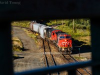 <b>Central Frame.</b> Framed in the walkway of the Central Ave bridge, an afternoon extra works Port Arthur with a pair of newly acquired Dash 8's of different lineage. CN 2170, formerly BNSF 817 and CN 2102 formerly UP 9067 which worked Fort Frances to Thunder Bay train A436 earlier that morning and are being used on a yard extra to pull and spot the elevators in the Intercity area of Thunder Bay as well build the train they will power later that night. As new GEVO orders have come been fulfilled, the Dash 8 numbers have dwindled a little over a decade after CN purchased them.