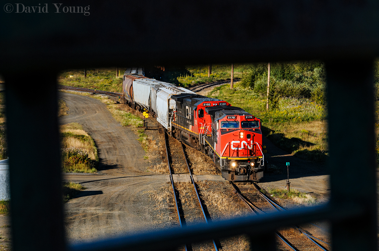 Central Frame. Framed in the walkway of the Central Ave bridge, an afternoon extra works Port Arthur with a pair of newly acquired Dash 8's of different lineage. CN 2170, formerly BNSF 817 and CN 2102 formerly UP 9067 which worked Fort Frances to Thunder Bay train A436 earlier that morning and are being used on a yard extra to pull and spot the elevators in the Intercity area of Thunder Bay as well build the train they will power later that night. As new GEVO orders have come been fulfilled, the Dash 8 numbers have dwindled a little over a decade after CN purchased them.