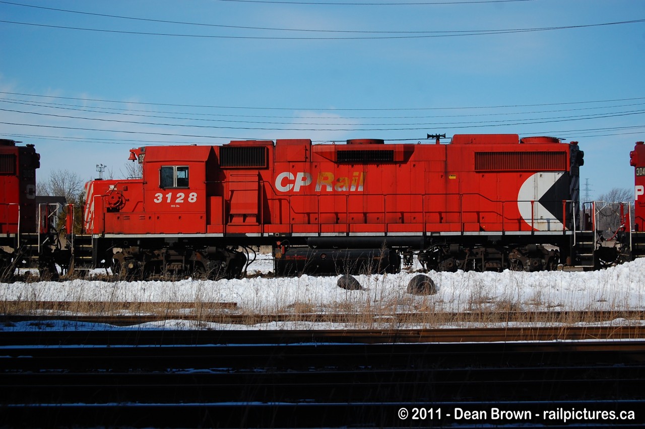 On a cold sunny afternoon in Cambridge, Ontario a CP GP38-2 3128 still has the old Packman logo back in March of 2011.