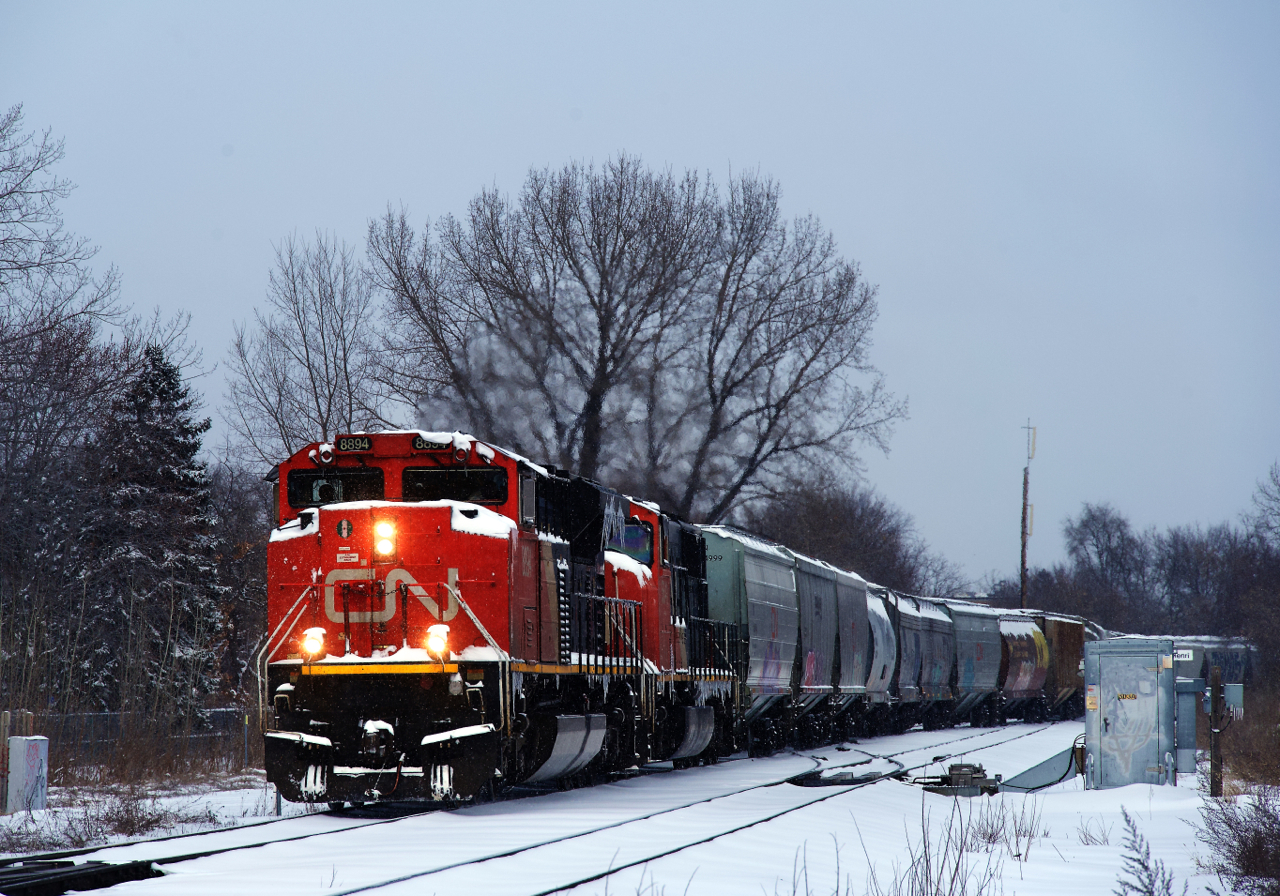 CN 8894 & CN 5641 is the power on CN 527, heading towards Taschereau Yard after working Pointe St-Charles Yard. Here it is crossing from the South Track to the North Track towards the end of a snowstorm.