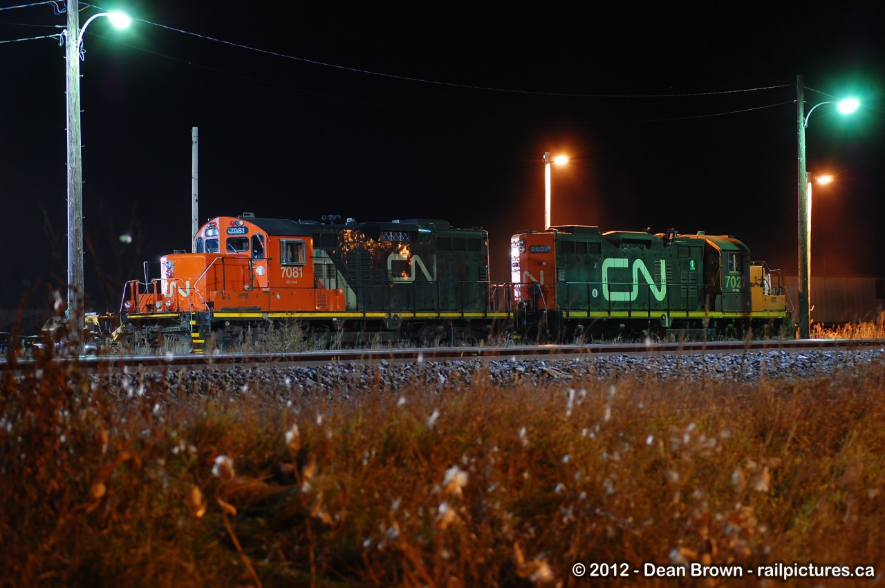 A pair of CN GP9RM 7081 and 7027 idlings in Belleville, ON in Nov 2012.