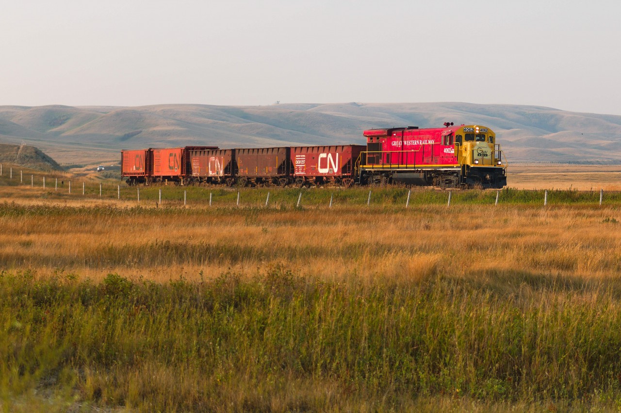 GWRS began ramping up MoW operations in the late summer through early winter of 2023, running regular Ballast trains to facilitate new siding construction across their system. The first generation of siding construction began in August, running 4062 solo between their ballast source in Horizon on the RCRR and the 3 new sidings at Valour, about halfway between Limerick and Assiniboia. This first operation took about 2 weeks to complete, sending 1-2 loads every weekday, with each load of ballast covering about half the siding length at Valour. From what I understand, these MoW operations continued onto other locations until November when a friend of mine went himself to catch grain season. Here they finish easing into the Willow Bunch Valley after starting the downgrade in Verwood as they follow the valley towards Assiniboia.