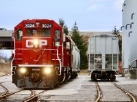 And then there was one. There was originally two CP served customers on what still survives today of the old Owen Sound subdivision. A number of years ago the customer on the east side of the main that received boxcars downsized and later shared space with the customer on the west side of the main that receives covered hoppers. I believe the company was Katoen Natie as I don’t think the name is on the building anymore. It has been weeks since a boxcar has appeared at the north end and the unloading ramps have disappeared. Typically local H24 once a week will make the just over a mile trip to beyond highway 401 to service this last industry, passing a pair of long severed spurs along the way. This dreary day fresh looking GP38-2 3024 along with 3134 are seen working the service tracks at the last customer. 
