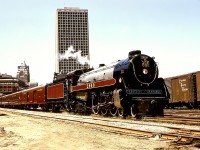 On Monday 1974-06-17, ex CP Royal Hudson 2860 departed the CP Vancouver depot for a new career, travelling east to Coquitlam (formerly Westminster Junction, now Westwood) then south to Sapperton, then west on BN to Willingdon Junction, then north on CN through the Thornton Tunnel and over the Second Narrows railway bridge to Lynn Creek and onward to North Vancouver on British Columbia Railway.  A combination of slow speed lifting from Vancouver and good timing on my part captured an ideal rods-down view with CP’s Granville Square office tower prominent in the background.