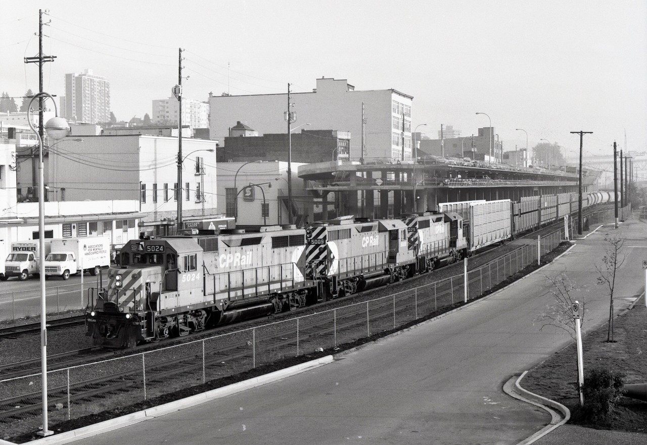 Along Front Street in New Westminster on Monday 1988-10-17 at 0915 PDT, a trio of GP35s, CP 5024 + 5009 + 5025, is arriving from Coquitlam yard in Port Coquitlam with a block of empty automobile racks on the headend for Annacis Island loading via interchange to Southern British Columbia Railway (just acquired 1988-10-01 by Itel Corporation from BC Hydro).

CP 5009 is in the middle of the consist since the two GP30s and early GP35s on CP were not equipped with Reset Sensing Control equipment instead of a deadman pedal, but 5011 up to 5025 were fully equipped for lead service.