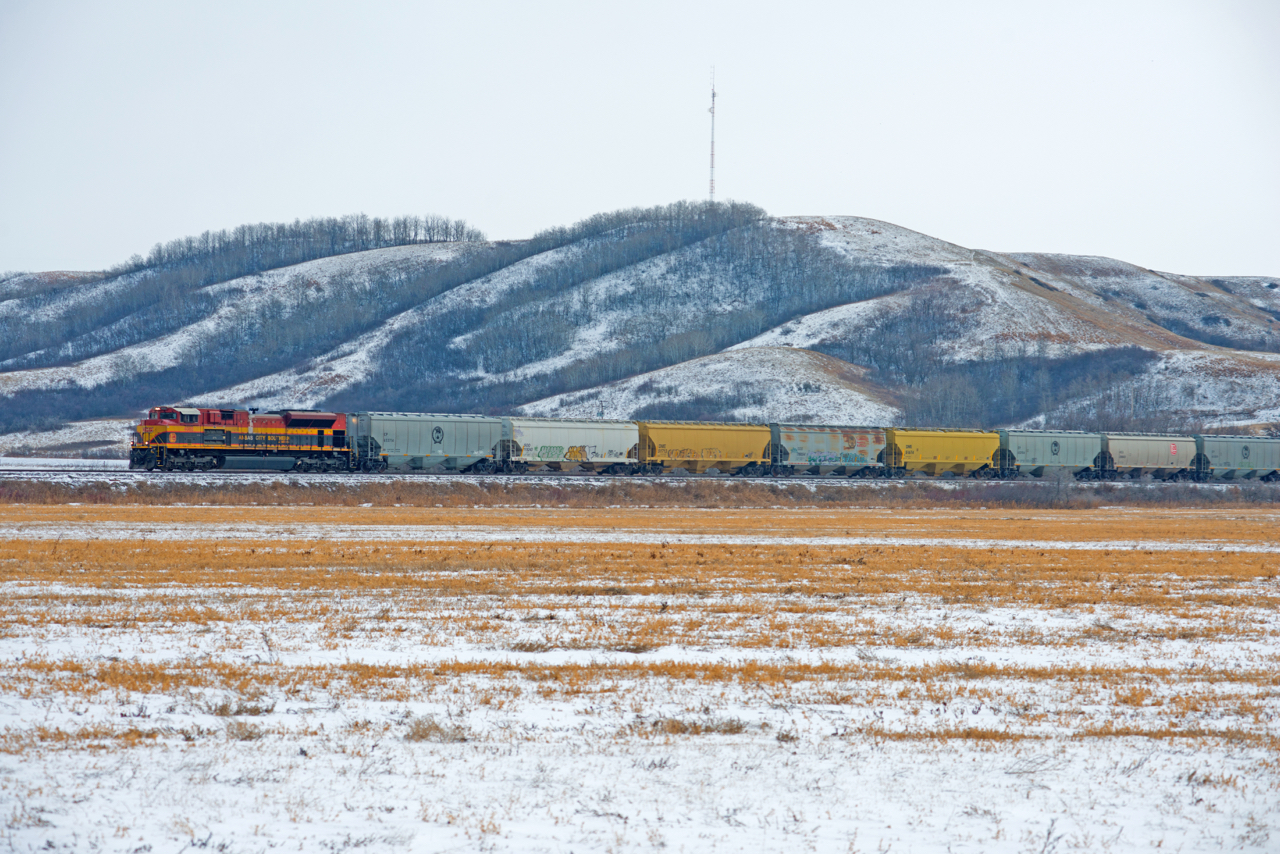 KCSM 4085 leads CPKC train E08 north on the Lanigan Sub with grain empties for Nokomis SK.