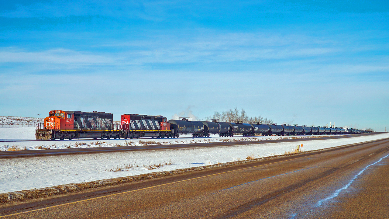 SD40-2(W)s CN 5279 and 5305 make their way south on the Scotford Industrial Spur with a cut of tank cars being transferred from the CPKC Scotford yard to the CN Scotford Yard.