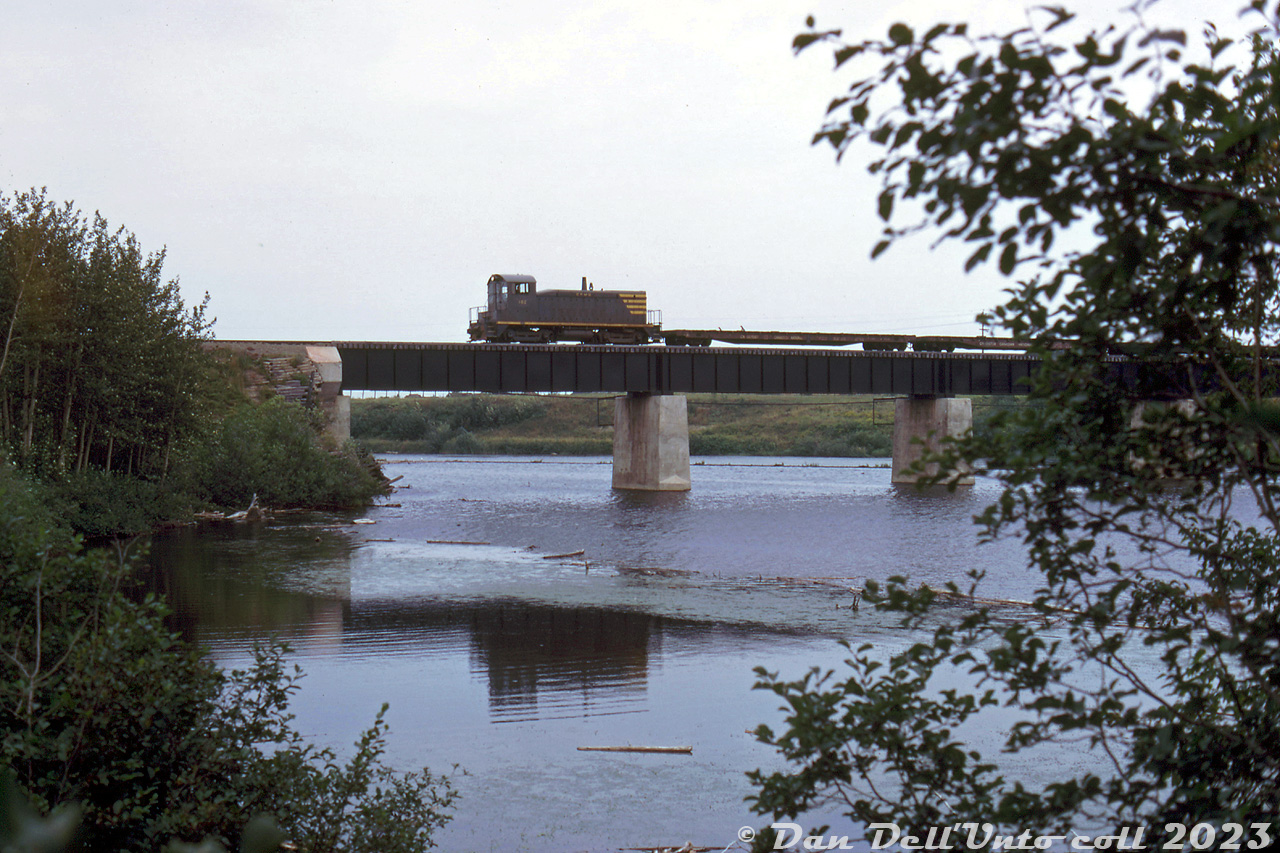 Canada and Gulf Terminal GMD SW8 102 (lettered for Chemin de Fer de Matane et du Golfe, CFMG) is heading westbound back to the yard at Mont Joli, seen here crossing the Mitis River at Price, Quebec.Canada and Gulf Terminal (Chemin de Fer de Matane et du Golfe, CFMG) was a small regional 36 mile shortline that handled mainly paper and lumber traffic along the south shore of the St. Lawrence River, in the Mont-Joli to Matane area. Their small roster included GE 70-tonner 101, SW8 102, and SW1200 103 (acquired from the R&S), as well as an ex-NYC doodlebug, and a combine used for mixed trains.CN took over the line in 1975, and a ferry operation was established between Matane and Baoie Comeau. One CN SW1200RS was even relettered for the CGT as 104. CN ran operations until spinning the line off in 1999 to the Quebec Railway Corp (who ran operations with CFMG-lettered 6900-series SD40-3's and ex-CP RS18u's). When CN purchased a handful of QRC's operations in late 2008, it again re-acquired this portion of the line.CFMG 102 was sold to Dofasco as their 27/427 a few years later, and eventually became a slug.Original photographer unknown, Dan Dell'Unto collection slide.