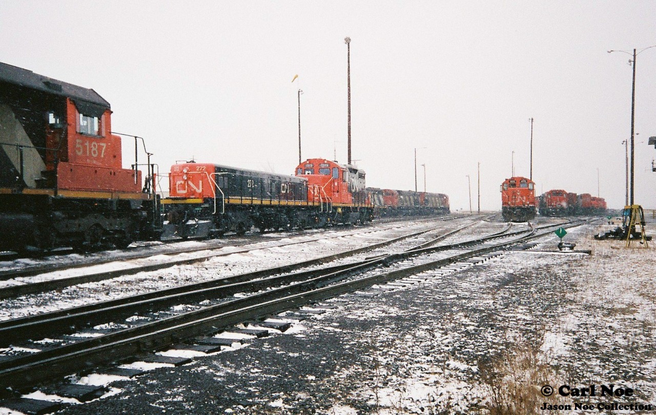 During early winter snow squalls, many locomotives are seen awaiting their next assignments on the CN MacMillan Yard diesel facility departure/ ready tracks in Vaughan, Ontario. Some of the units included SD40 5187 and GP9RM 7272 with GP9 Slug 272. On July 7, 1993 both 7272 and 272 were released from remanufacturing at the AMF facility (former CN Pointe-Saint-Charles shops) in Montreal, Quebec. They were rebuilt from former CN GP9’s 4208 and 4212.