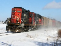 During a frigid February afternoon, CN L568 heads west to Stratford with GP9RM 7025 and GP38-2 4705 seen passing Mile 72 on the Guelph Subdivision in Baden, Ontario. 