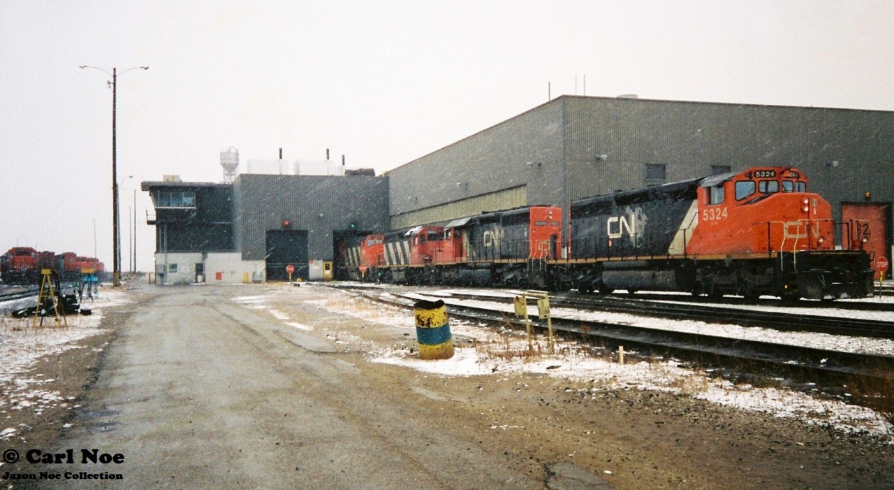 During early winter snow squalls, several locomotives are viewed slowly entering one of the service bays at the CN MacMillan Yard diesel facility in Vaughan, Ontario. Some of the units included SD40-2(W) 5324, SD40u 6005 and GP40 9310.