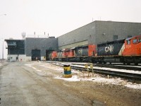 During early winter snow squalls, several locomotives are viewed slowly entering one of the service bays at the CN MacMillan Yard diesel facility in Vaughan, Ontario. Some of the units included SD40-2(W) 5324, SD40u 6005 and GP40 9310. 