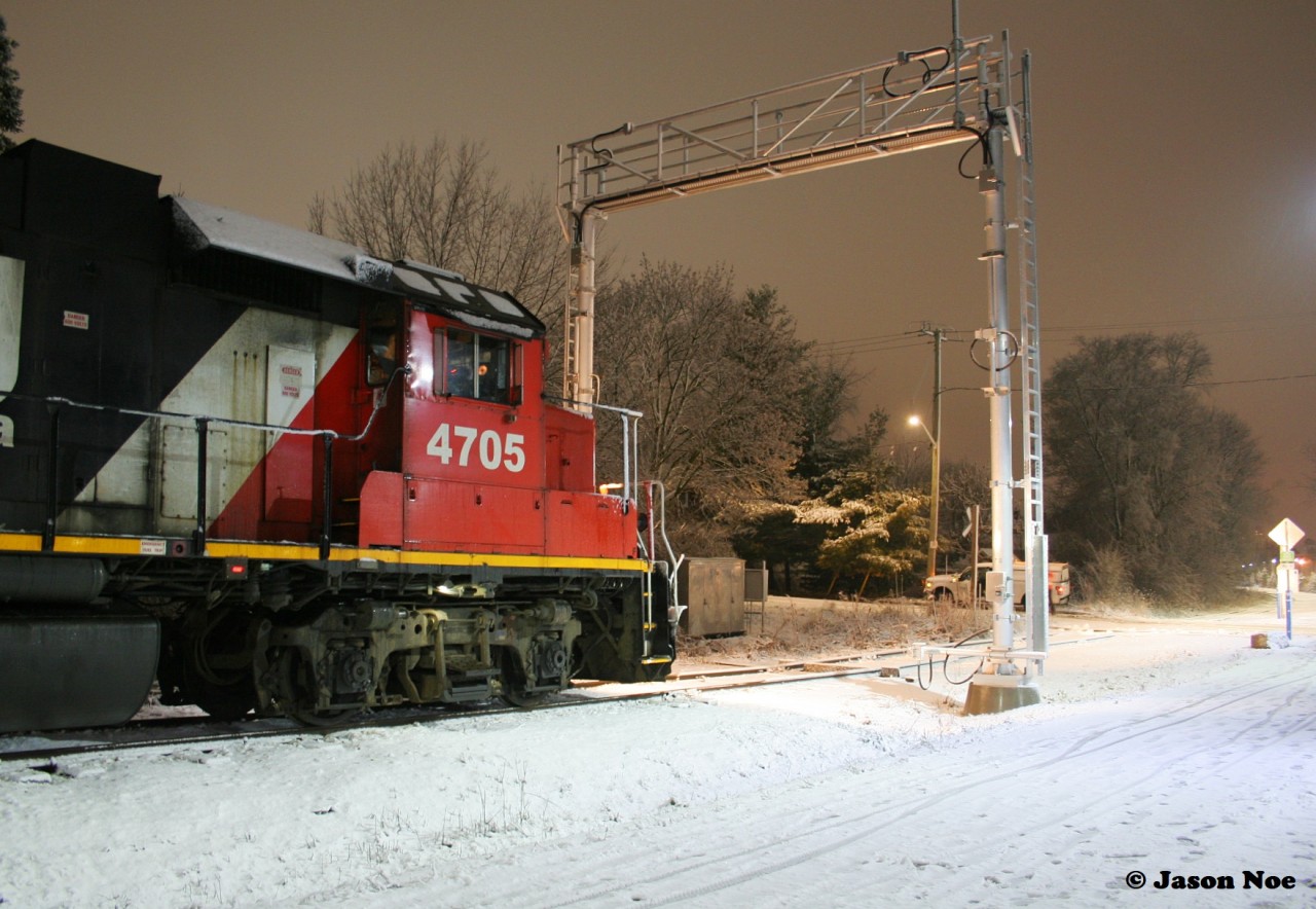 CN L566 with 4705 and 7025 wait patiently for a Siemens Canada worker to clear the sensors on the ION high and wide detector at Roger Street in Waterloo. Prior to L566’s arrival, an early evening snowfall had coated the area in a fresh blanket of white. Once the sensors were cleared by the worker, L566 was able to proceed north on the Waterloo Spur to the chemical companies in Elmira.