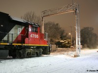 CN L566 with 4705 and 7025 wait patiently for a Siemens Canada worker to clear the sensors on the ION high and wide detector at Roger Street in Waterloo. Prior to L566’s arrival, an early evening snowfall had coated the area in a fresh blanket of white. Once the sensors were cleared by the worker, L566 was able to proceed north on the Waterloo Spur to the chemical companies in Elmira. 