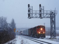 Thick snow is falling as CN 324 heads east with CN 8901, CN 2220 and 38 cars.
