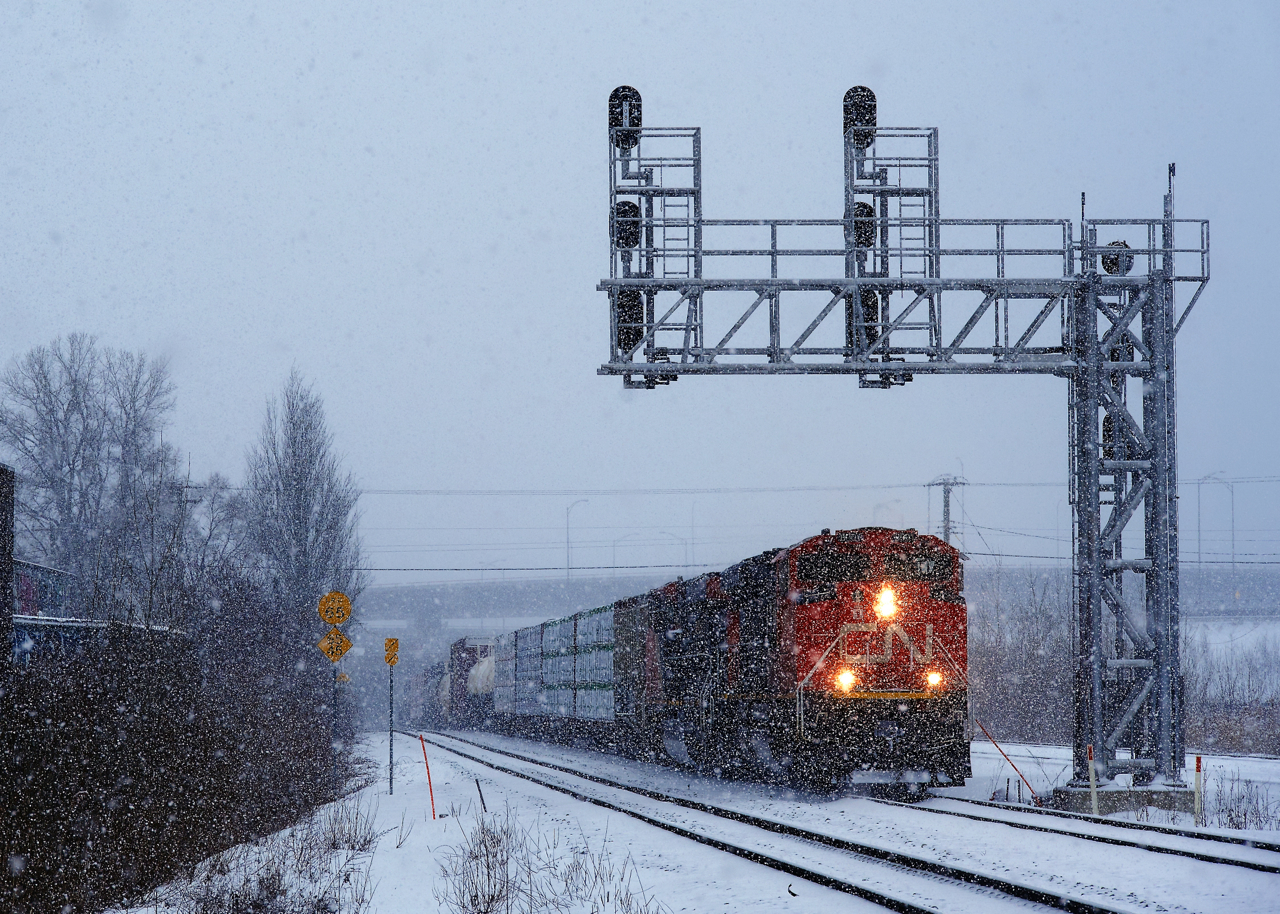 Thick snow is falling as CN 324 heads east with CN 8901, CN 2220 and 38 cars.