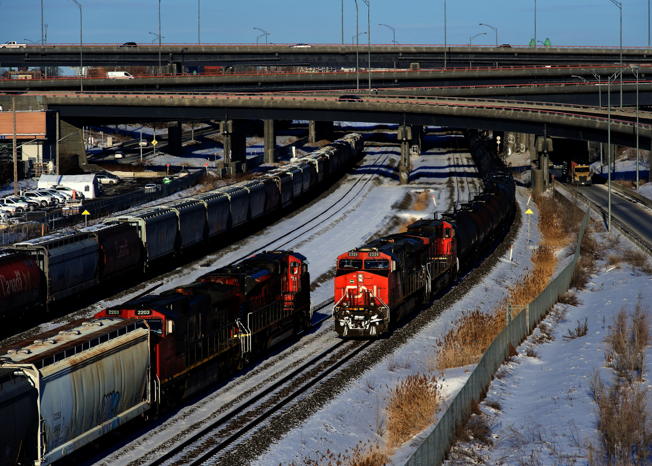 CN 543 at left (with CN 322's train) and CN 527 at right meet just west of the Turcot Interchange on a frosty afternoon. At left are parked grain cars.