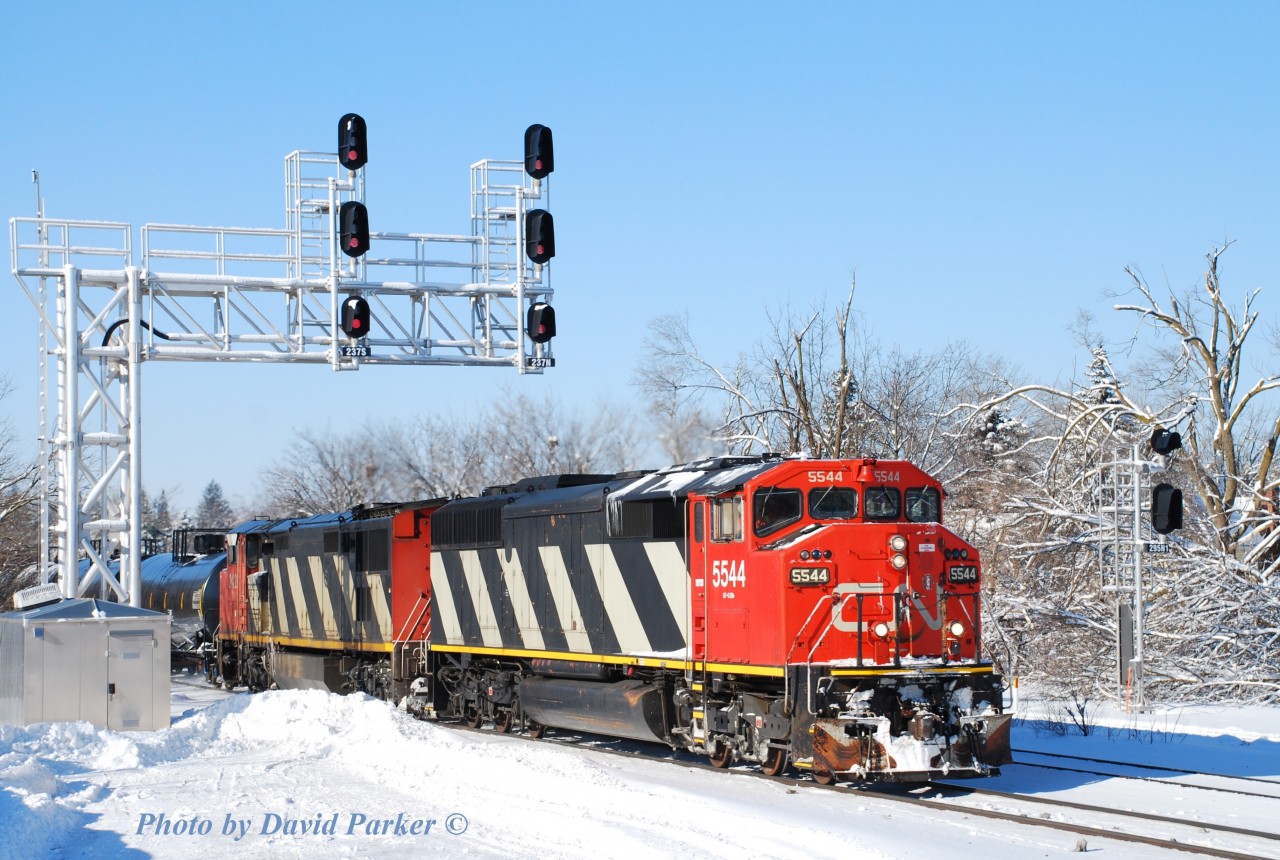 The view from atop "El Capitan' (A huge snowpile at the Westend of the GO parking lot) as an Eastbound led by CN 5544-CN 2428 passes through Georgetown on Feb 7th 2014. The trees in the background show the damage from the December 23rd Ice Storm that hit Southern Ontario.