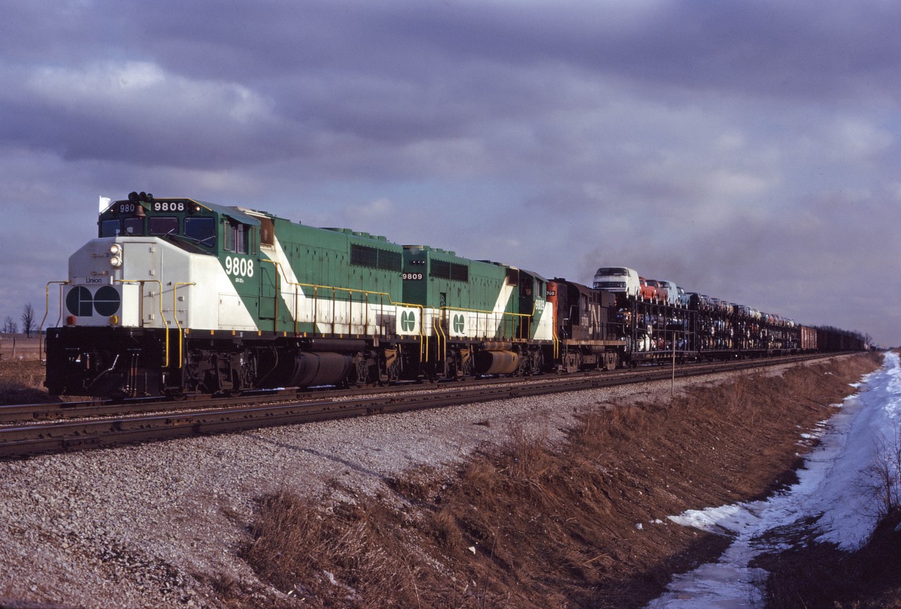 Prior to the start of GO service to Georgetown in late April 1974, GO GP40-2LWs were broken in on CN freight trains. Here we have the 9808 and 9809 accompanied by CN RS18 3708 on an eastbound to Toronto Yard. GO's first seven GP40-2LWs were renumbered into the 700 series in the mid-1970s. The 9808 and 9809 were sold to CN in 1991 and assigned numbers 9668 and 9669.