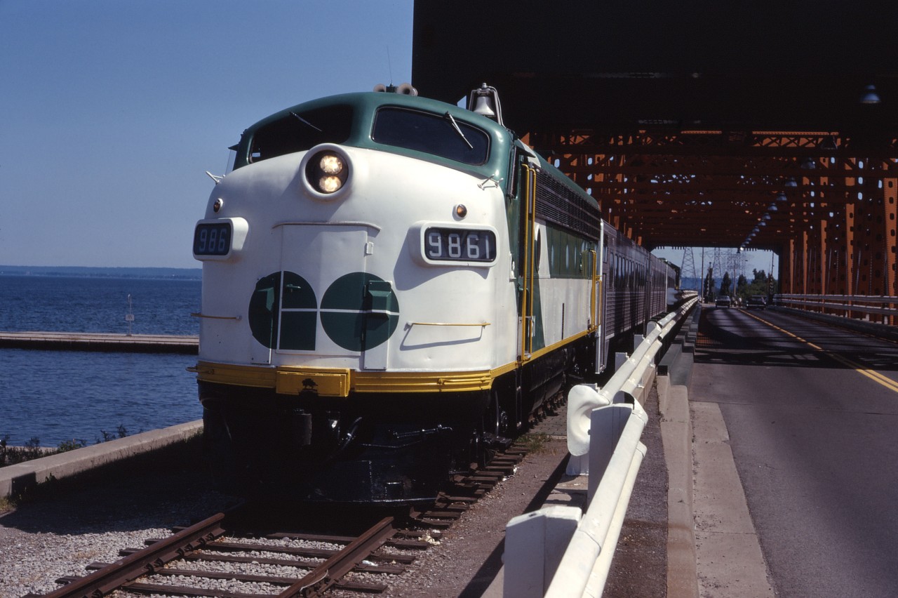 What is it that Monty Python used to say..."And now for something completely different". Well, you can say that again--a GO train on the Beach sub! This trip was sponsored by the Electric Railroader's Association on July 6, 1974 during the ERA's annual convention. The day started out with a TTC subway train charter then, after lunch, ran an excursion using new GO GP40-2LW 9810 and ACPU 9861 (ex ONT FP7 1512) and three single level coaches. The train ran northwest to Georgetown, down to Hamilton, over to Stoney Creek and across the Beach sub, before returning to Toronto over the Oakville sub. Here the train is shown at the Burlington Canal lift bridge at mile 4.8. (Caption information from the July-August 1974 UCRS Newsletter.)
