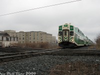 GO Transit cab car 233 leads train #801, the first Barrie line train of the PM rush hour parade out of Union Station, northbound up the CN Newmarket Subdivision. GO F59PH 549 on the rear has slowed its pushing, and the train is about to slam the Davenport diamond interlocking plant with <a href=http://www.railpictures.ca/?attachment_id=32382><b>CP's North Toronto Sub</b></a>, just north of Dupont Avenue.<br><br>The gentrification is strong in this former industrial bastion of Toronto: the tan building in the background is the old American Standard plant (manufacturer of sanitary products like toilets), that had been converted into lofts. On the left was the old Canadian General Electric (CGE) Royce Works plant at Dupont and Lansdowne (Dupont used to be called Royce Street). Most of the plant, once spanning that entire southwest quadrant of the diamond, had been demolished. The original building at the corner was spared, and incorporated into the new condos later built on site. There was once a connecting track between CN and CP here (parts remained in the weeds), used for interchange and accessing some of the local aforementioned industries. On the northeast quadrant (out of frame) was the old CGE Davenport Works, partially converted into lofts and housing (the north headhouse had been converted, the south headhouse was eventually demolished. Apparently there was lots of PCB contamination on the site from decades of manufacturing electrical transformers).<br><br>Davenport would continue to see GO bilevels clatter over the diamond until <a href=http://www.railpictures.ca/?attachment_id=51598><b>April 2023</b></a>, when the new grade separation opened under Metrolinx ownership. A concrete flyover and more condos greets anyone standing in this spot today.