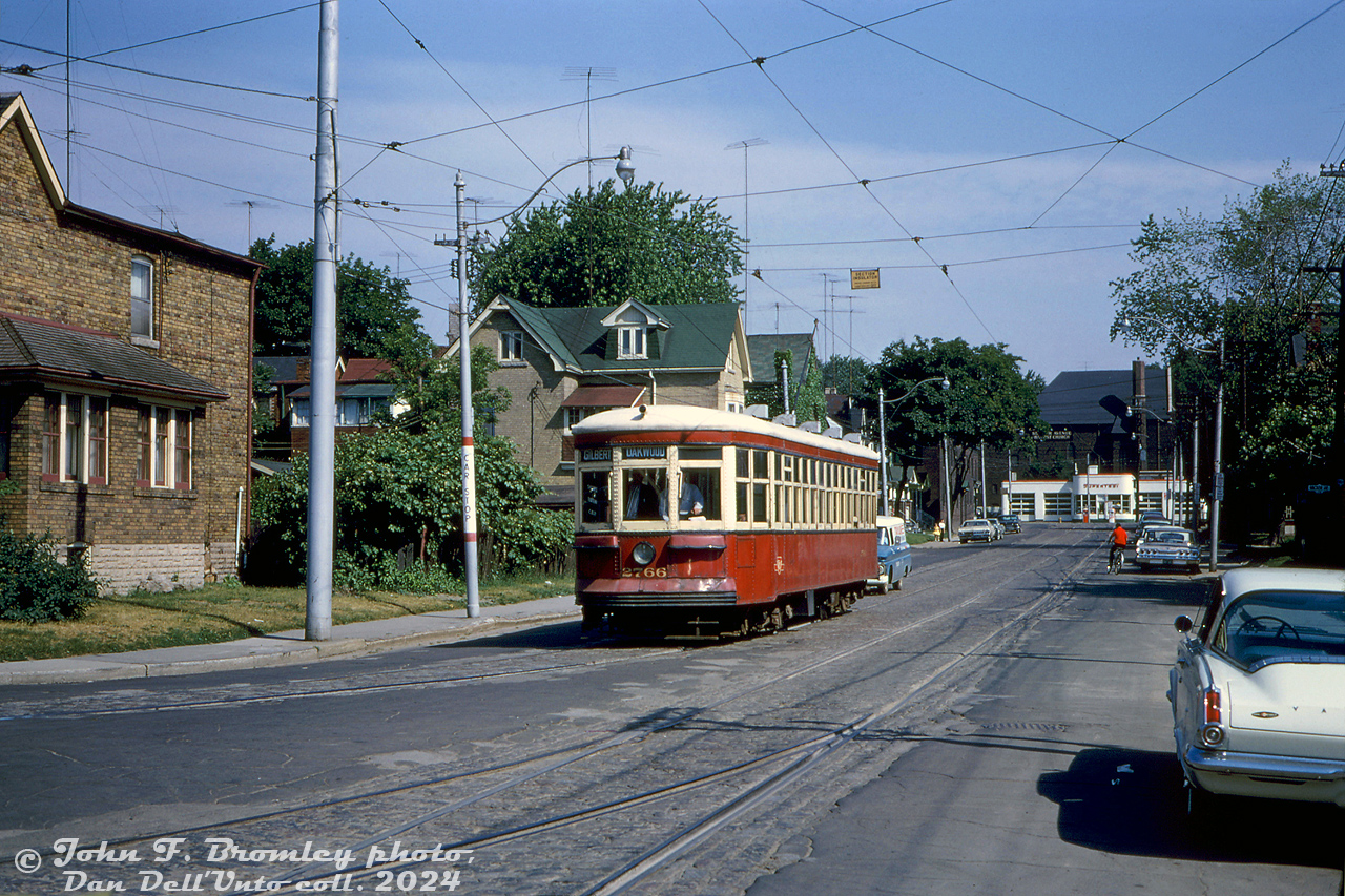 TTC Peter Witt streetcar 2766 is seen returning back to the yard from an overnight fantrip around the city, and is shown about to enter the back of St. Clair (Wychwood) Carhouse yard on the tracks off Wychwood Avenue at Benson Avenue. St. Clair Avenue can be seen in the distance. Photographer John Bromley's white mid-60's Plymouth Barracuda is visible parked on the right (sold as a Valiant Barracuda early on in Canada, hence the trunk lettering).

By 1965, the few remaining cars of TTC's fleet of old Peter Witt streetcars were facing their last months of revenue service (most were retired in 1963 when the University subway line opened, the remaining cars saw infrequent use), and enthusiasts often chartered cars for fantrips while they were still active. Photos show during this June 27th 1965 overnight and morning fantrip, 2766 made visits to Mimico, Dufferin Loop, Runnymede Loop, Viaduct Loop, Harbourfront Loop, Bedford Loop, and St. Clarens Loop. 2766 was the last active car, retired in July 1965, but kept by the TTC and later refurbished for Tour Tram service in the early 1970's.

John F. Bromley photo, Dan Dell'Unto collection slide.