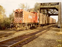 The west end of CP’s Coquitlam Yard (always in the City of Port Coquitlam, how logical!) was marked by a two-track through steel truss bridge over the Coquitlam River.  Here, on Wednesday 1972-11-04, Baldwin switcher 7070 (an engine I came to know well six years later on Vancouver Island) is wearing a fairly fresh coat of paint and is busy sorting a string of cars, at a then nameless location previously (before 1928) Westminster Junction and later (1988) MacAulay.  That bridge continues to serve to this day.