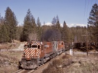 Northward from Cranbrook to Kimberley on what is now the Northstar Rail Trail used to be CP’s Kimberley subdivision, primarily to serve Cominco operations at Kimberley.  On my first solo road trip to the Kootenay region, a northward train of empties was followed from Cranbrook, with a big MLW, CP 4501, leading and a plain SD40, CP 5518, trailing, Nearing Kimberley, at a crossing of Knighton Road (mileage not recorded) in the area known as Chapman Camp, nearly 50 years ago on 1974-04-25, an everyday scene was caught, before SD40-2s in their increasing numbers took over in the west.
