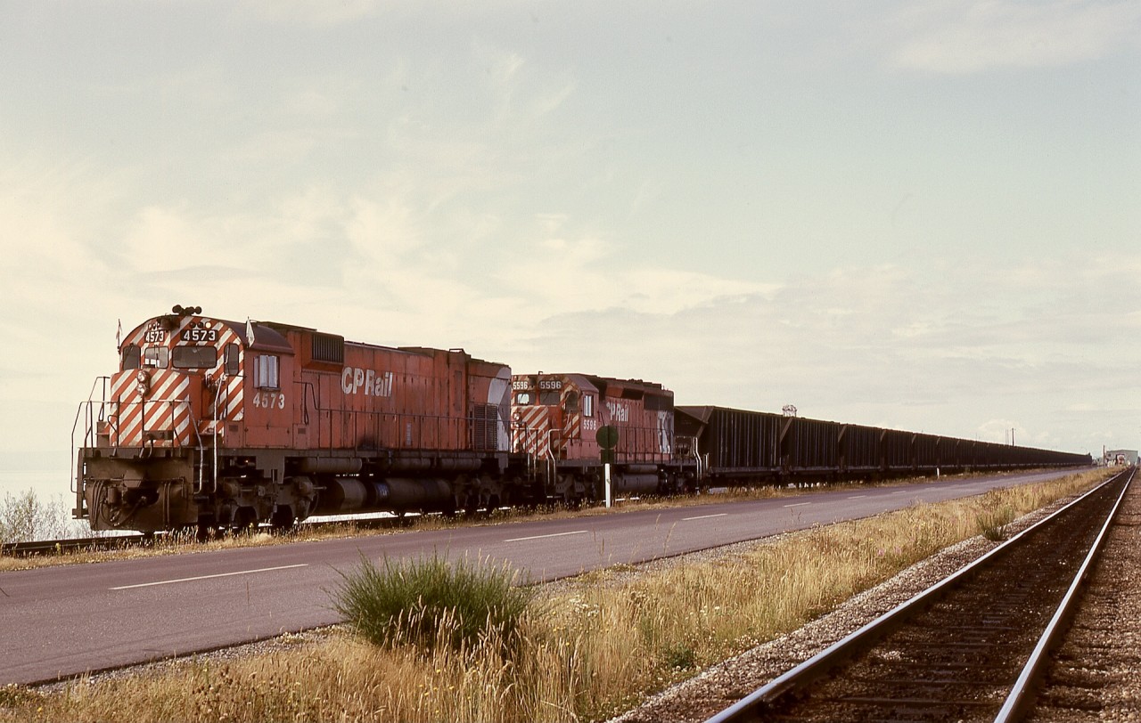 When the Roberts Bank coal terminal was first constructed, railway infrastructure was just a single line on the north side of the causeway roadway, as seen on the right of this photo, with the unloading loop switch just before the single-car rotary dumper visible in the distance.  With increased traffic, a track was added on the south side of the causeway roadway for emptied trains to await their next crew, which is what 4573 and 5596 and unseen remotes are doing on Friday 1974-07-05.  

Note the caboose just clear of the dumper in the distance.  The original loop track ran counter-clockwise, now completely rearranged to an offset clockwise loop with numerous storage tracks on the north side of the roadway, plus an immense intermodal facility this side of the loop track.

Check https://vancouversun.com/business/local-business/port-of-vancouvers-contentious-roberts-bank-terminal-2-proposal-6-things-to-know for an indication of accumulated growth in the last fifty years and plans for even more intermodal capacity.  I am glad to have known it from when it was a youngster.