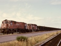 When the Roberts Bank coal terminal was first constructed, railway infrastructure was just a single line on the north side of the causeway roadway, as seen on the right of this photo, with the unloading loop switch just before the single-car rotary dumper visible in the distance.  With increased traffic, a track was added on the south side of the causeway roadway for emptied trains to await their next crew, which is what 4573 and 5596 and unseen remotes are doing on Friday 1974-07-05.  

<p>Note the caboose just clear of the dumper in the distance.  The original loop track ran counter-clockwise, now completely rearranged to an offset clockwise loop with numerous storage tracks on the north side of the roadway, plus an immense intermodal facility this side of the loop track.

<p>Check https://vancouversun.com/business/local-business/port-of-vancouvers-contentious-roberts-bank-terminal-2-proposal-6-things-to-know for an indication of accumulated growth in the last fifty years and plans for even more intermodal capacity.  I am glad to have known it from when it was a youngster.
