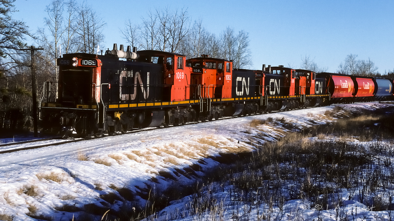 Extra 1069 was rounding the corner at mile 24.4 with a train of grain hoppers as it returns back to Edmonton. Interesting grouping of the units, CN's at each end, ex-NAR's in the middle.