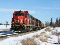 CN L568 with GP38-2's 4708 and 4710 along with GP9RM 7025 are viewed heading westbound to Stratford, Ontario, just west of the town of New Hamburg, approaching Road 102. 