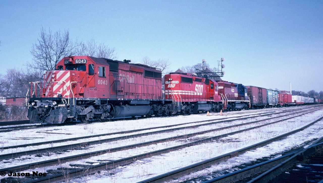 A CP westbound with SD40-2 6043, SOO Line SD40-2 6606 and Helm Leasing SD40 6100 waits for a new crew to head west from London, Ontario's Quebec Street Yard to Windsor. Helm SD40 6100 is former Burlington Northern SD40 6305 and it was released from the AMF facility in Montreal, Quebec a couple weeks earlier on February 15 and was destined for Chicago, Illinois. Reportedly, this unit was previously leased to CP. 

Also noted in the train were several passenger/baggage cars. Unfortunately, I don’t have any information on what they were or their destination.