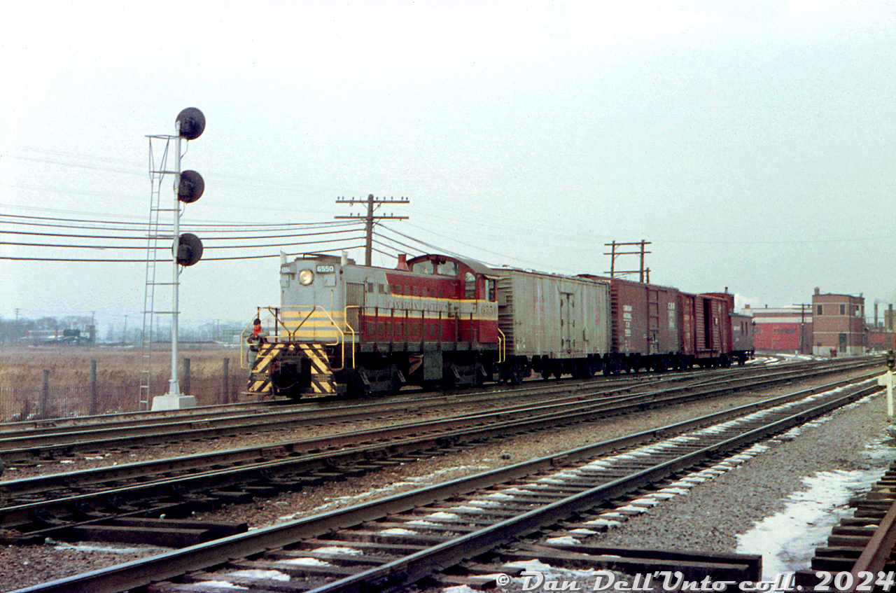 Canadian Pacific MLW S3 6550, sporting a pair of white extra flags, comes off the CP Canpa Sub with a short local job entering CN's Oakville Sub at the Canpa interlocking (note the brick Canpa tower in the background, governing CN and CP traffic). CP had a longstanding agreement with CN for running rights over the Oakville Sub between downtown Toronto (Bathurst St./Cabin D) and Hamilton Junction, and CP locals often came from West Toronto/Lambton Yard area down the Canpa to work some of the joint-section industries along the Oakville Sub, as well as interchange cars with CN at their Mimico Yard (the trailing steel CN ice reefer and 40' boxcar might be interchange traffic for CN).

It took a bit of love to coax some colour and contrast back into this old faded Eddie Blacks colour slide. No date or date stamp was visible, but it was likely taken sometime in the late 1950's to early 1960's.

Original photographer unknown, Dan Dell'Unto collection slide.