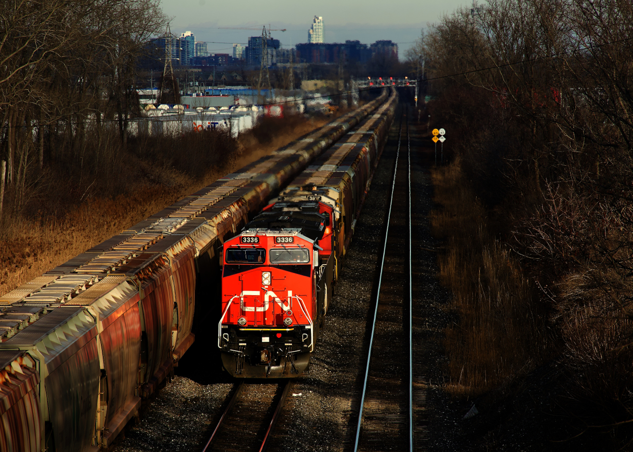 Potash trains meet as empty potash train CN B731 passes parked and loaded potash train CN B730 near Ballantyne. Recently rebuilt CN 3336 is leading.