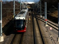 A westbound O-Train is approaching Tremblay Station in Ottawa. At this Station, passengers can get to or from the VIA Rail Station.