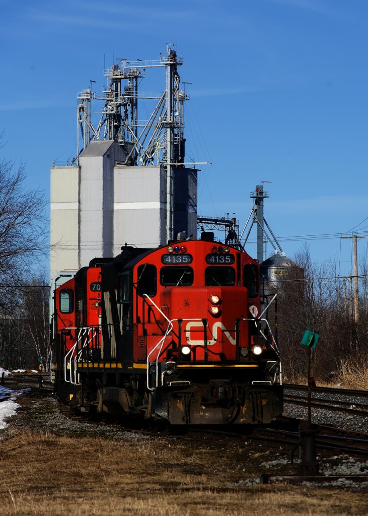 CN 587 with a pair of GP9s has just lifted a single hopper from the mill in the background. It will couple that car to the rest of the train and then head south to the next client, in Crabtree.