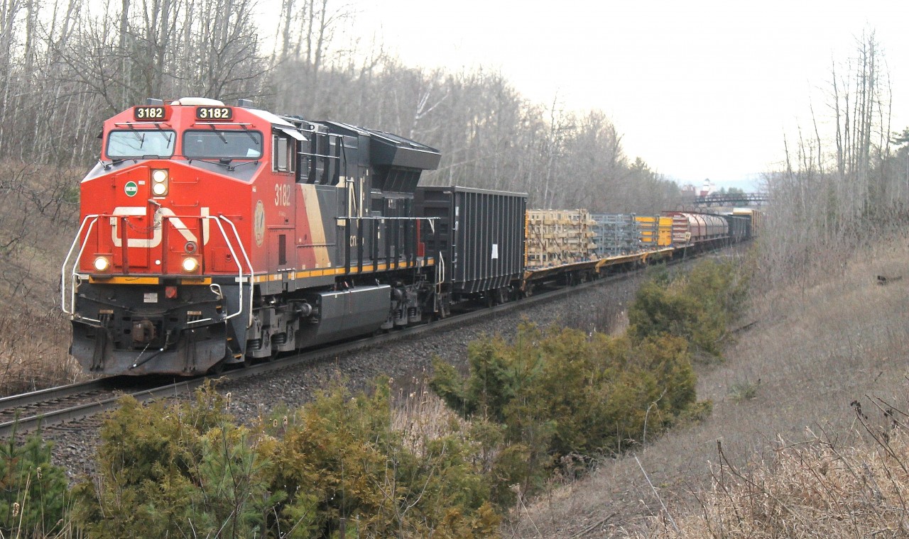 CN train flies through mile 30 on a cloudy morning with CN 3182 a solo tier 4 in lead.