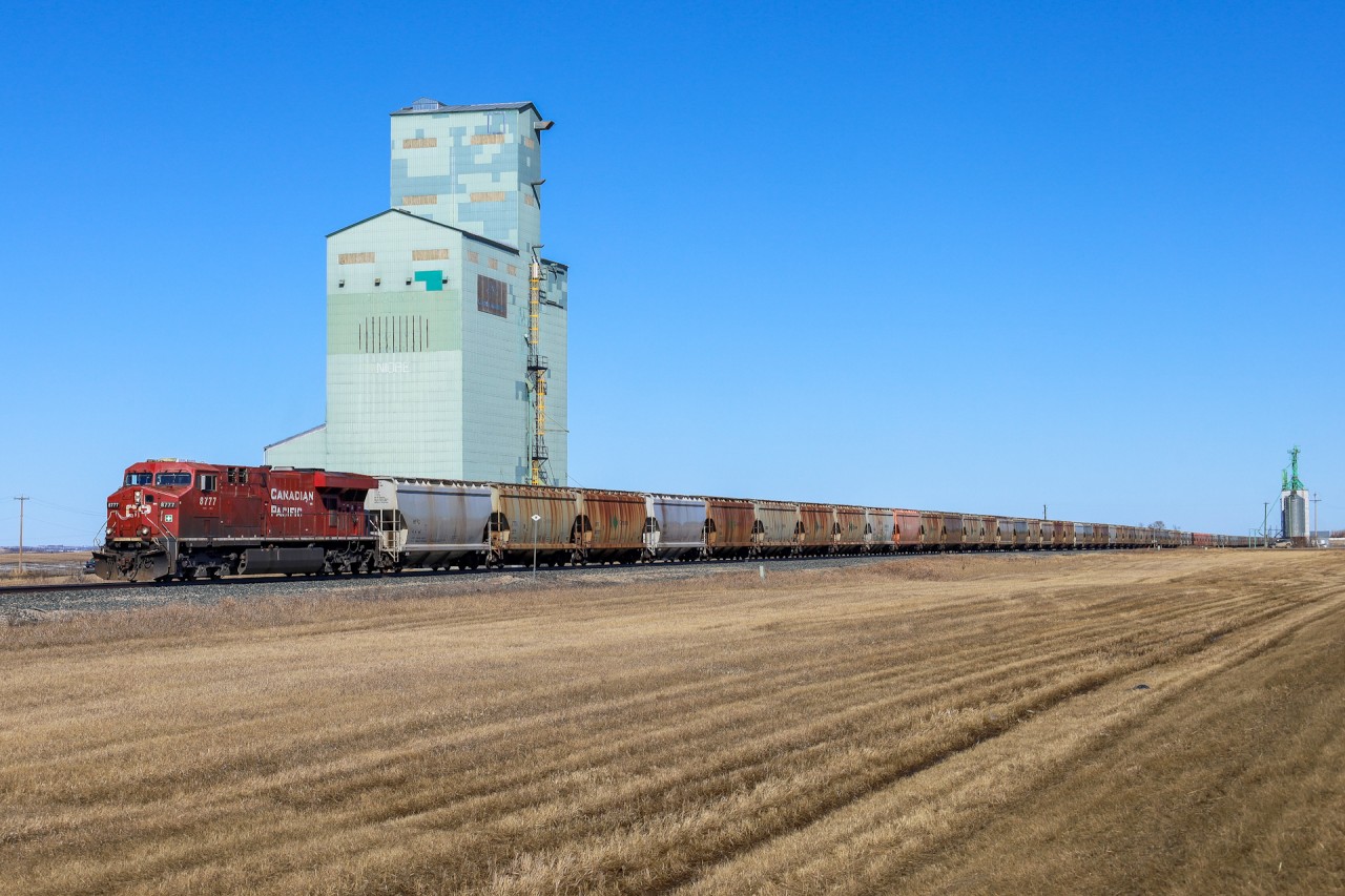 CP 8777 South leads potash train 605 past the old elevator after meeting CP 2816 north at Penhold.