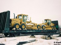 A CN bulkhead flatcar loaded with brand new Champion road graders is seen at the CN yard in Stratford, Ontario on February 6, 1994. Presumably, it will eventually be lifted by either CN 421 or 422 to continue its journey. The new equipment was brought down from Goderich via the Goderich-Exeter Railway after being lifted from the Champion Road Machinery plant in the town. 
In 1997 Volvo had paid $173-million to take over Champion Road Machinery. However, in 2008 it was announced they were going to close the road grader plant by 2010, eliminating 500 jobs, and consolidating its road machinery operations in Pennsylvania. At the time, Volvo had said this move was made to improve competitiveness and profitability while reducing exchange rate fluctuations as our Canadian dollar had risen incredibly high.  
