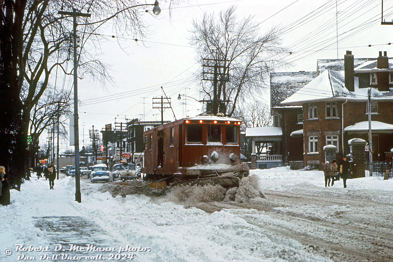 Not your regular Toronto streetcar: TTC Snow Sweeper S-30 plies its trade along the streets of Toronto, clearing snowy slush from Broadview Avenue near Wolfrey Avenue as a line of cars builds up behind.Having a large streetcar network across the city, it was important to keep the tracks clear during winter weather. For decades, the TTC had its own fleet of snow-clearing equipment, including rail-mounted snow sweepers and snow plows (apparently they even had regular snow-clearing routes they were sent out on). TTC S-30, originally built for the Third Avenue Railway System of New York in the early 1920's, was equipped with a set of motorized rotating bristles at both ends and side plow blades to push the snow back. Bristles worked better than a plow blade to clear snow out of the flangeways of streetcar tracks. They were even used to couple up to and push stranded or disabled streetcars stuck in the snow.The snow sweeper fleet was phased out by the early 70's, in favour of the city's own snow removal. A few stored sweepers could be found still lingering around the back tracks of Roncesvalles Carhouse yard as late as 1973.Robert D. McMann photo (duplicate slide), Dan Dell'Unto collection slide.