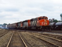 Brake shoe smoke swirls around trailing freight cars as a trio of GMD SD40 variants roll an eastbound extra into Brantford.<br><br><i>Original Photographer Unknown, Jacob Patterson Collection.</i>