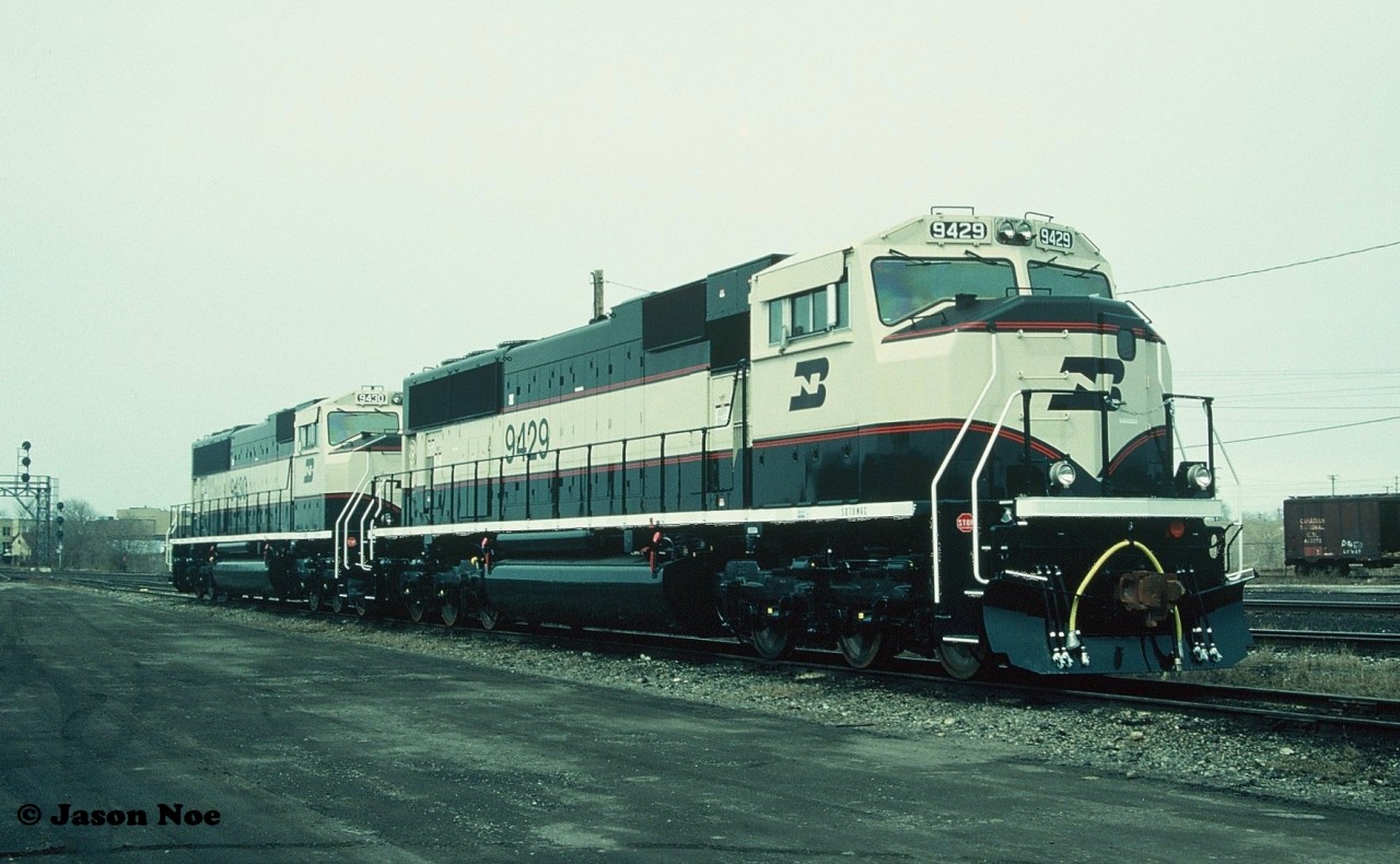 In 1993, Burlington Northern had placed a record setting 350-unit order with GMDD in London, Ontario for 4,000 horsepower SD70MAC’s totalling $675 million. In December 1993, the first one, BN 9400 rolled-off the assembly line at the London plant with 349 more to follow over the course of the next couple years. Painted in the BN “Executive Scheme” the units departed London for delivery to BN in Chicago via both CN and Canadian Pacific. Here BN 9429 and 9430 are viewed at CN’s yard in London waiting to be lifted after having made the short trip from the GMDD plant.