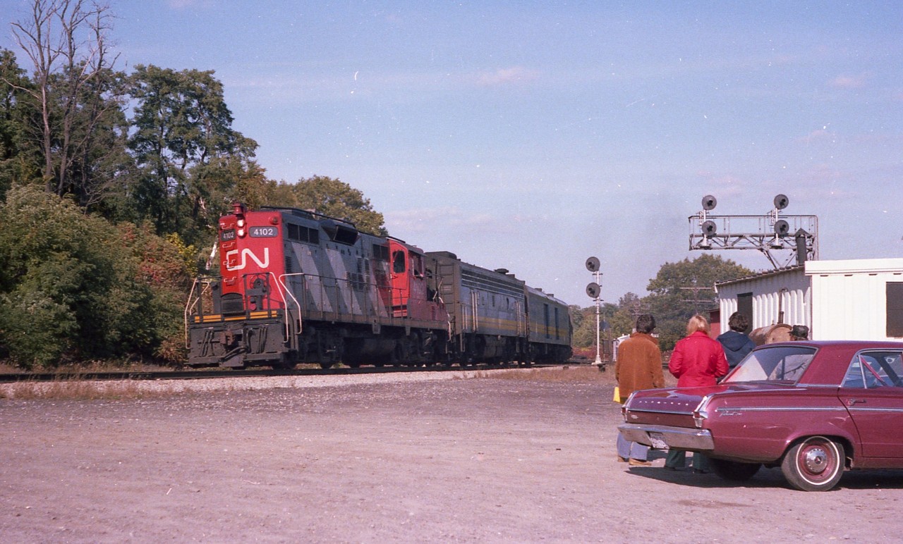 The scene is a rather peaceful afternoon at Bayview Junction, back before the hassle-free days came to an end. A trio of railfans watch CN 4102 & 6622 heading westward from Toronto.  This might be the mid-afternoon #83, now long gone from the timetable. Although we are in the very early days of VIA, their newly painted B unit already looks rather grubby.