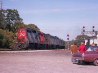 The scene is a rather peaceful afternoon at Bayview Junction, back before the hassle-free days came to an end. A trio of railfans watch CN 4102 & 6622 heading westward from Toronto.  This might be the mid-afternoon #83, now long gone from the timetable. Although we are in the very early days of VIA, their newly painted B unit already looks rather grubby.